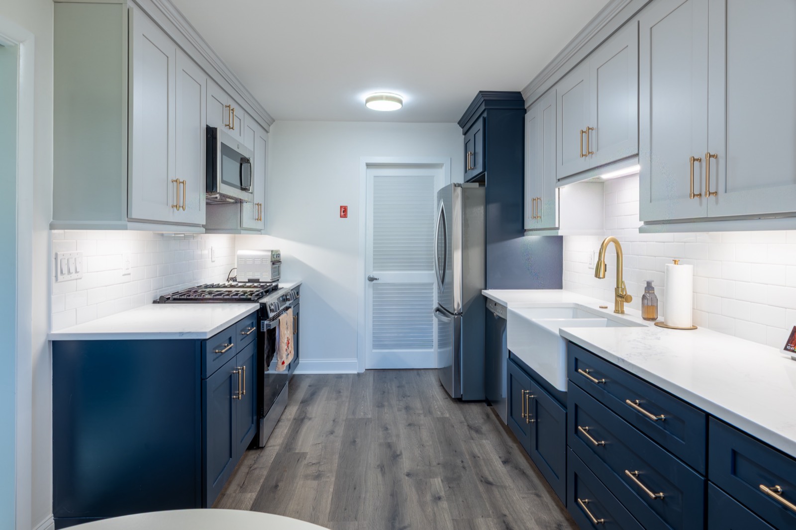 After: galley kitchen with navy and light-blue shaker cabinets