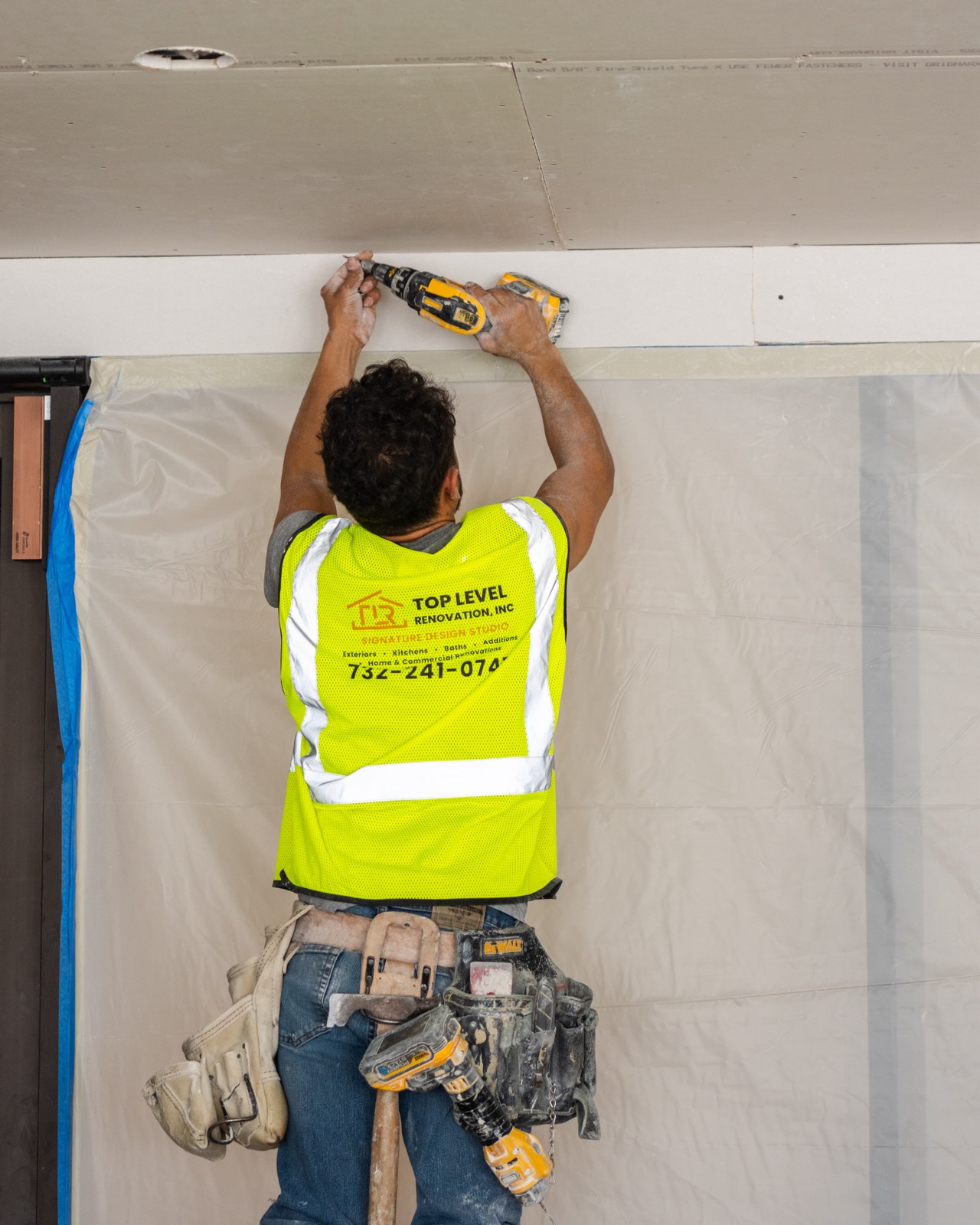 Top Level crew member installing drywall on a commercial job