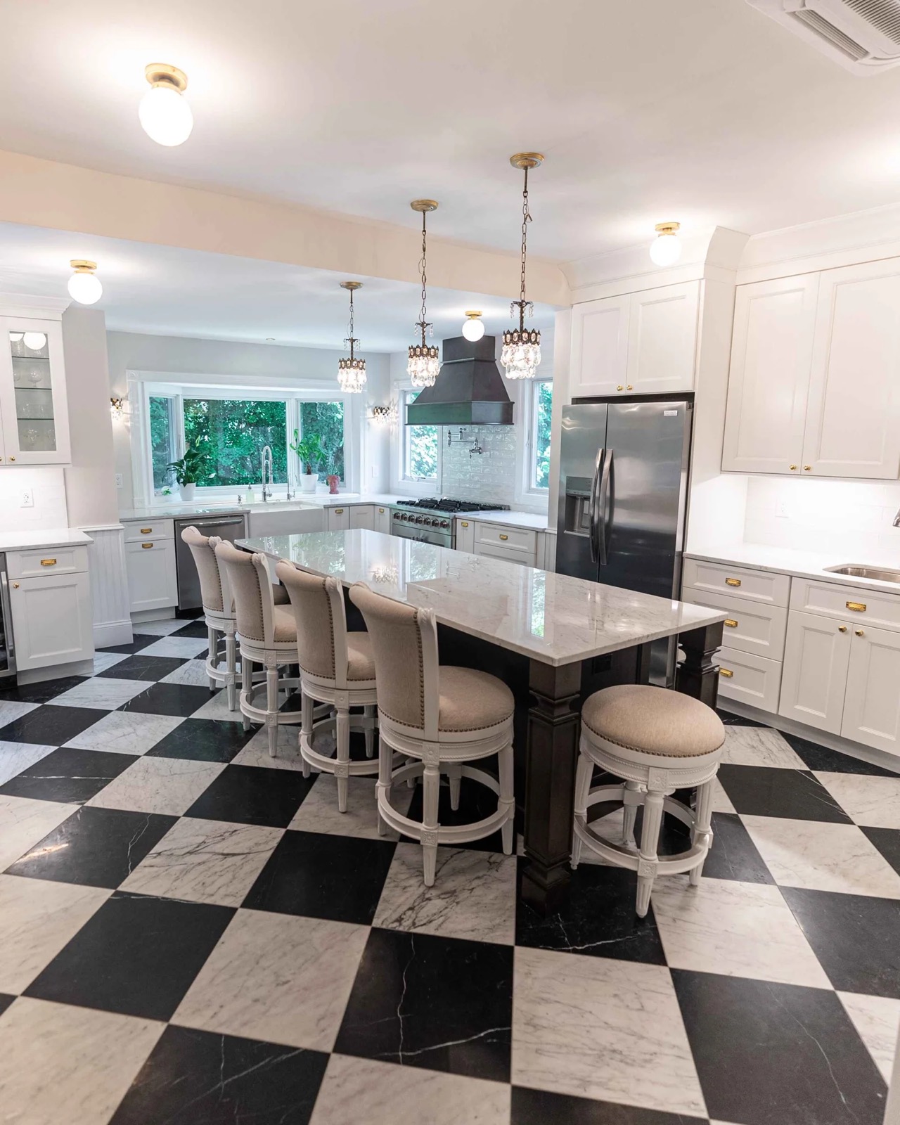 Kitchen with black island, marble counters and checkerboard floor