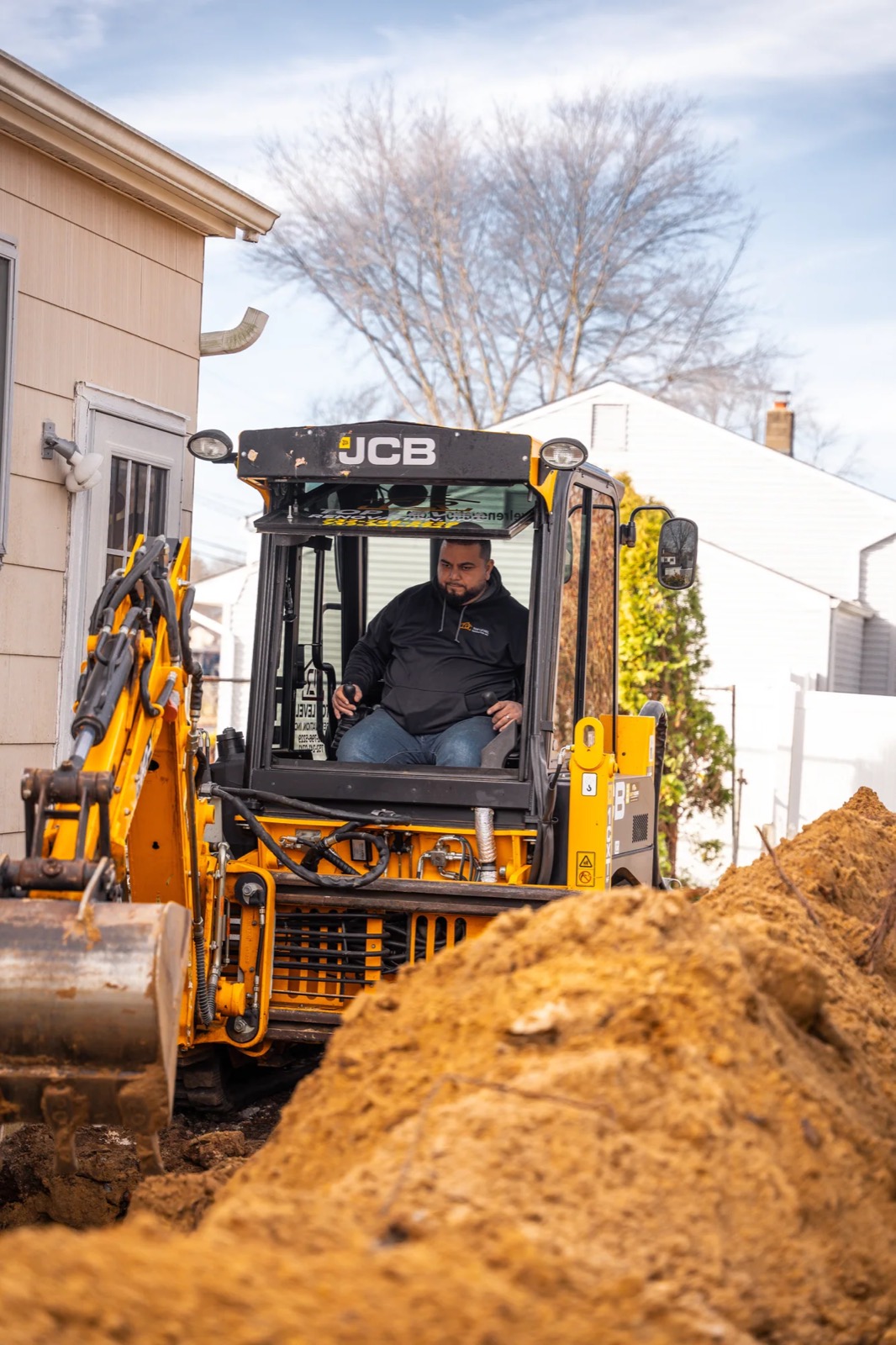 Excavator digging a foundation on a Howell job site