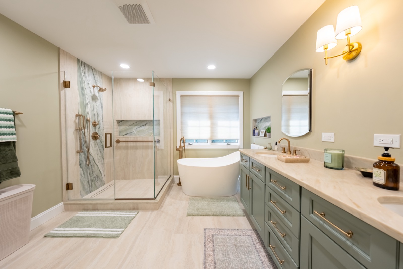 Primary bath with sage double vanity, freestanding tub and glass shower, finished August 2026