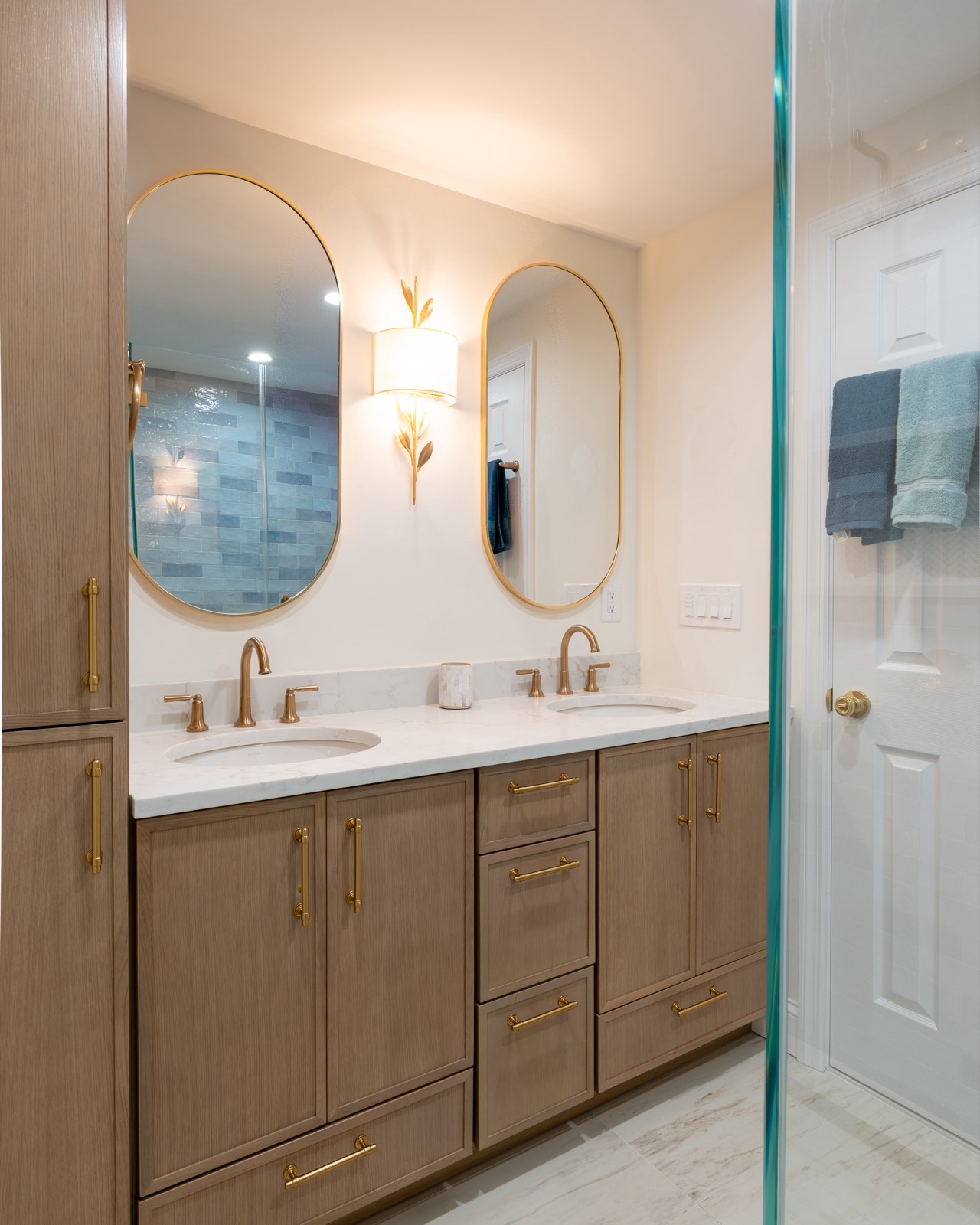Double vanity with brass fixtures and blue tile shower