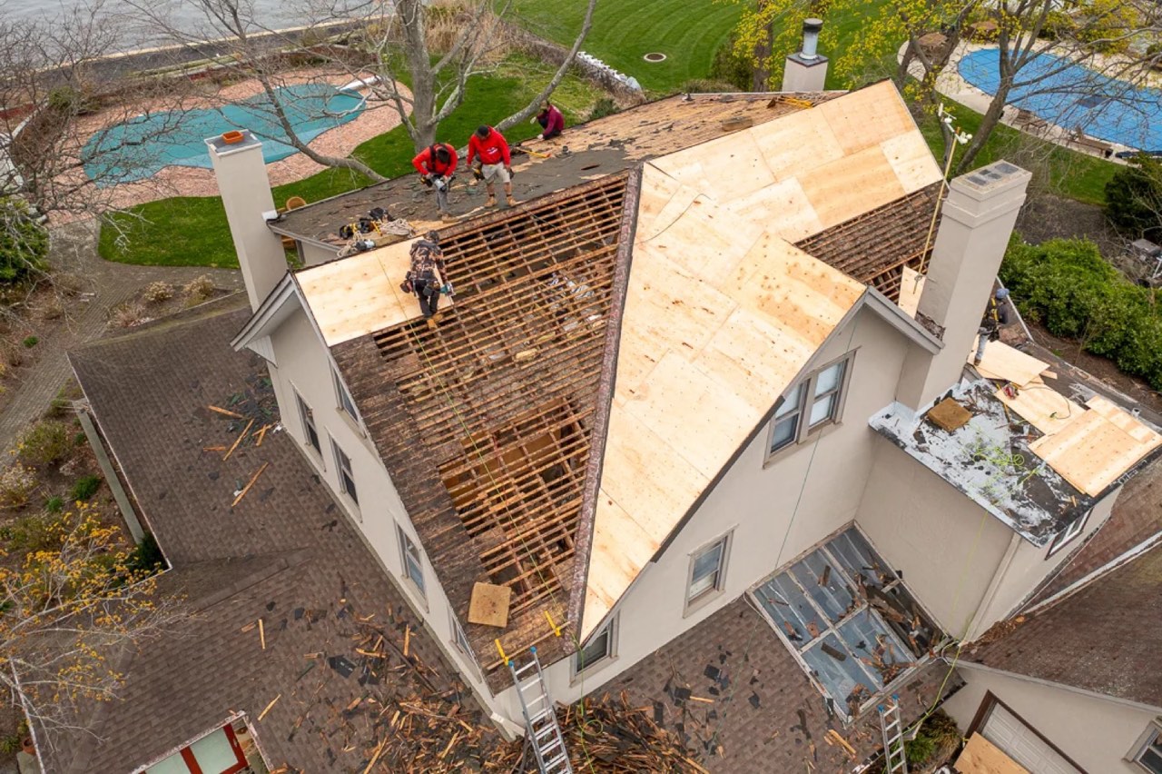 During: crew tearing off the old roof down to the decking