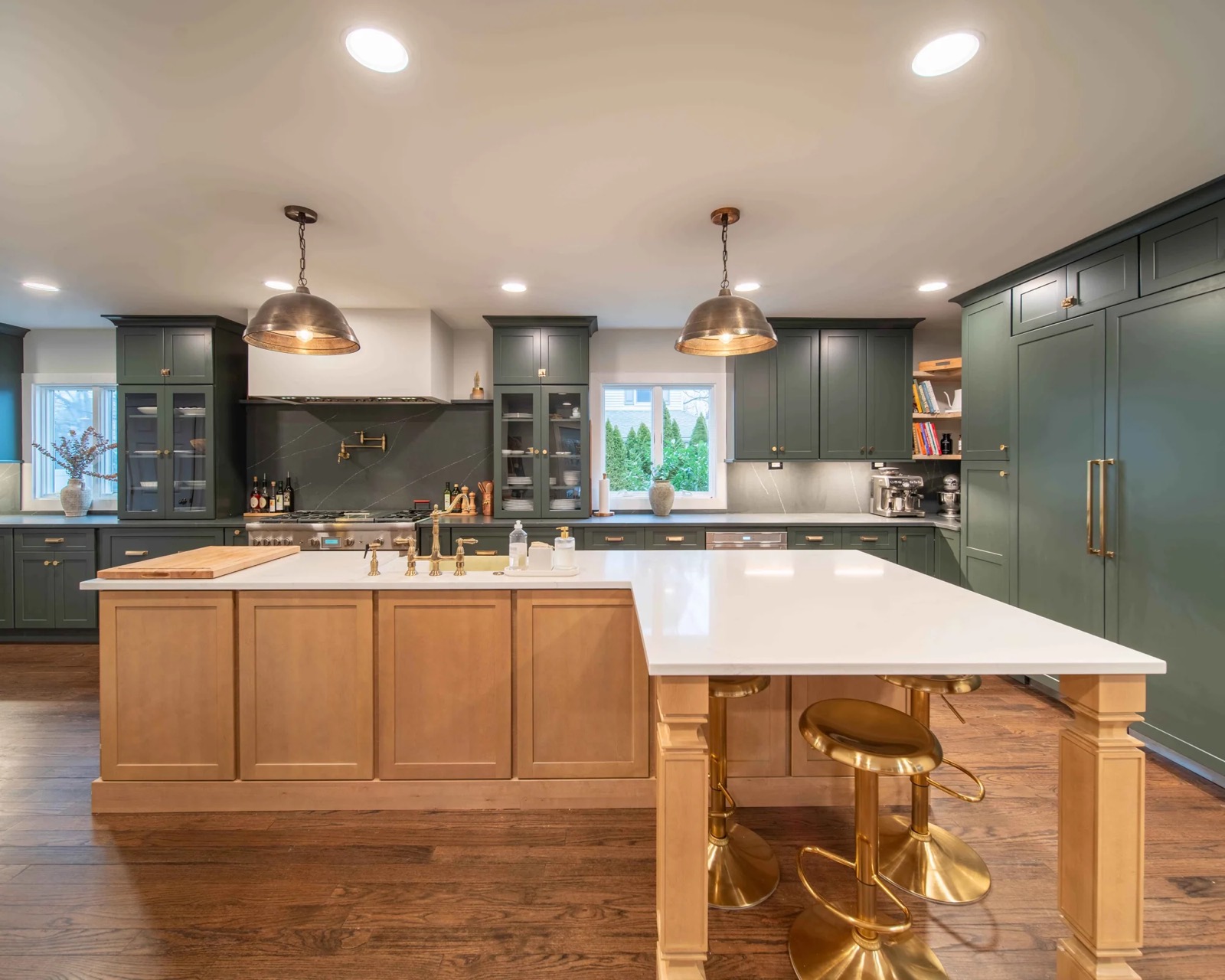 Green kitchen with white-oak island and gold stools